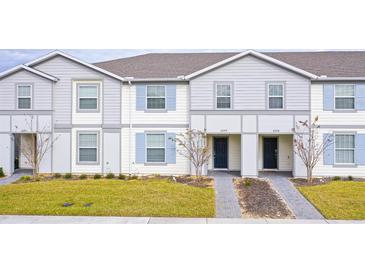 Two-story townhouses with gray siding, blue shutters, and landscaped lawns at 4298 Lana Ave, Davenport, FL 33897