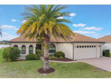 Single-story home with palm tree, landscaped yard, and two-car garage at 5521 Hogan Ln, Winter Haven, FL 33884