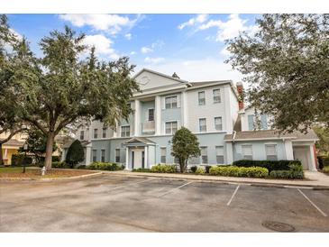 Two-story building exterior with parking and landscaping at 7703 Heritage Crossing Way # 302, Reunion, FL 34747
