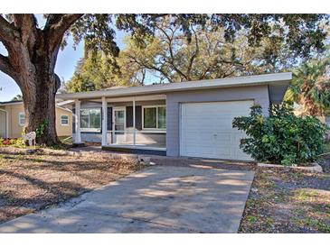 Charming ranch home with screened porch, large oak tree, and spacious driveway at 1246 Margina Ave, Daytona Beach, FL 32114