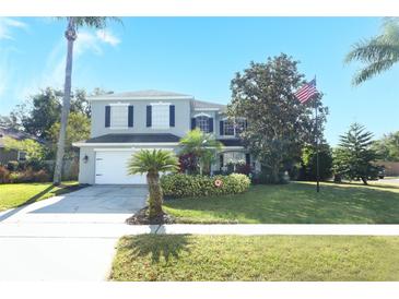 Two-story house with gray siding, landscaping, and a white garage door at 355 Carriage Way Ct, Oviedo, FL 32765