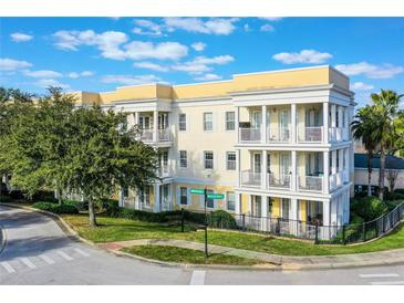 Three-story building with balconies and lush landscaping at 7501 Mourning Dove Cir # 202, Reunion, FL 34747