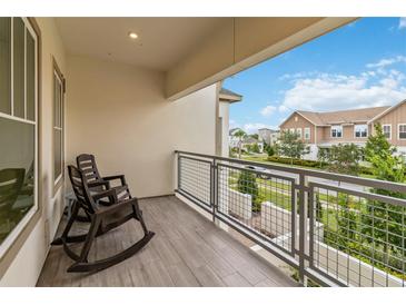 Relaxing balcony with gray wood-look floors and metal railing overlooking the neighborhood at 13444 Stoddart Ave, Orlando, FL 32827