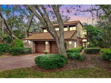 Charming two-story home features a brick facade, two-car garage, and mature landscaping at 136 Woodmill Rd, Longwood, FL 32779