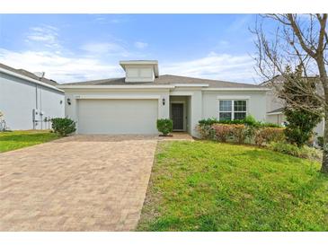 Charming single-story home with a well-manicured lawn and a brick driveway at 1504 Finchburg St, Minneola, FL 34715