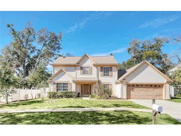 Two-story house with beige siding, brown roof, and a two-car garage at 2102 Country Side Dr, Apopka, FL 32712