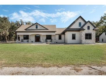 Two-story house with stone accents, a large front porch, and a spacious lawn at 2850 Horton Rd, Kissimmee, FL 34744