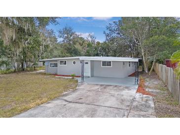 Newly renovated house with gray exterior, landscaping, and driveway at 32650 Azealia Pl, Tavares, FL 32778