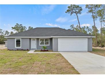 Newly constructed home with gray siding, attached garage, and well-manicured lawn at 4386 Sw 169Th Lane Rd, Ocala, FL 34473