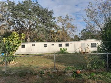 Single-wide mobile home with a chain link fence and a basketball at 5149 Bryant Ave, Sanford, FL 32773