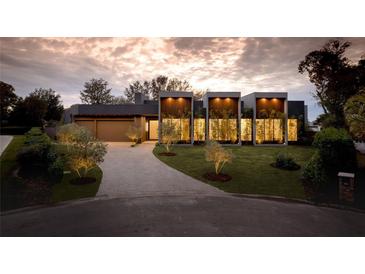 Modern home with a sleek design, landscaped yard, and a paved driveway at 8968 Bay Cove Ct, Orlando, FL 32819