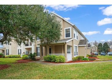 Inviting exterior of a two-story townhome with landscaping and a covered porch at 9125 Lee Vista Blvd # 706, Orlando, FL 32829