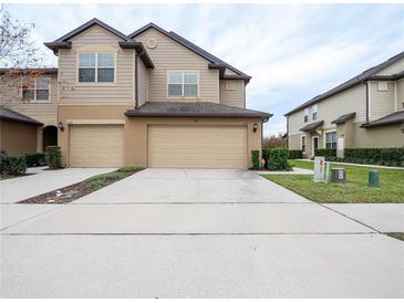 Two-story tan house with two-car garage and landscaped lawn at 1164 Pavia Dr, Apopka, FL 32703