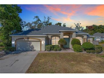 One story house with a green door, attached garage and landscaping at dusk at 140 Rangeline Woods Cv, Longwood, FL 32750