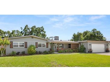 Charming single-story home boasts lush landscaping, a brick facade and a detached two-car garage at 1792 Killarney Dr, Winter Park, FL 32789