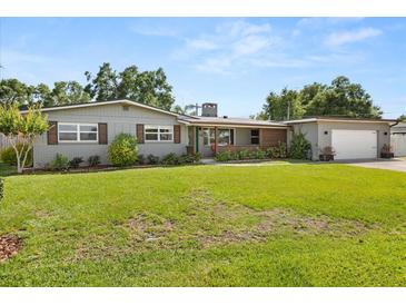 Charming one-story home with gray brick, brown trim, a spacious lawn, and mature trees at 1792 Killarney Dr, Winter Park, FL 32789
