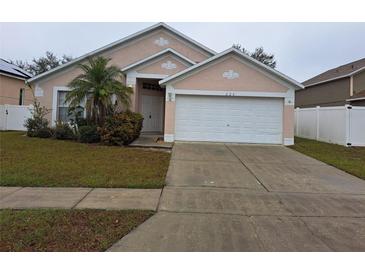 Attractive single-story home with a two-car garage and well-maintained lawn at 220 Ronaldale Ave, Haines City, FL 33844