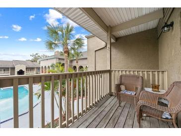 Relaxing balcony with wicker chairs overlooking the community pool at 425 Wymore Rd # 203, Altamonte Springs, FL 32714