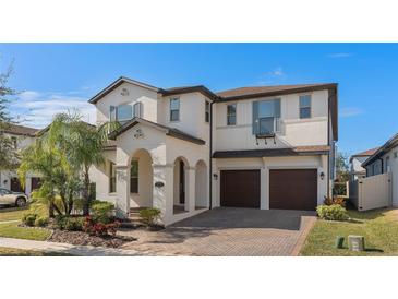 Two-story house with two-car garage, landscaped yard, and brick driveway at 8324 Vivaro Isle Way, Windermere, FL 34786