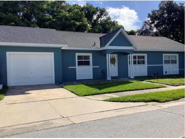 Newly painted blue home with a white door, one car garage and well-maintained lawn at 8495 Barnstable Pl, Orlando, FL 32827