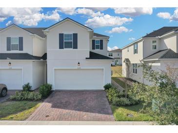 Two-story townhome with attached garage and brick driveway at 1122 Seaside Mist Trl, Kissimmee, FL 34747