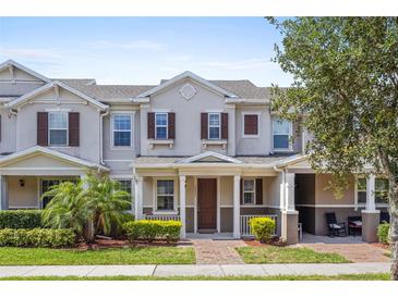Charming townhome featuring a cozy front porch and beautiful landscaping in a well-maintained community at 13731 Bravante Aly, Windermere, FL 34786
