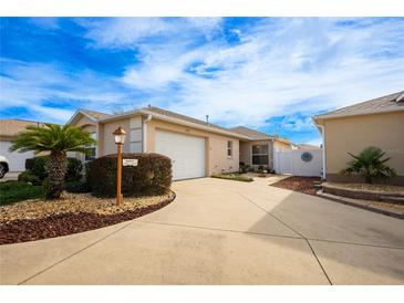 Front view of charming villa with attached garage and landscaped entry at 1849 Dalton Dr, The Villages, FL 32162