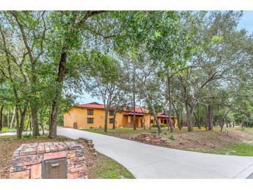 Spanish style home with a red tile roof and landscaped yard at 3141 Oak Alley Dr, Apopka, FL 32703