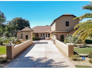 Stunning exterior showcasing a long private drive leading to the attractive home and lush landscaping at 38207 Sabal Way, Umatilla, FL 32784