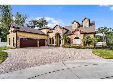 Two-story house with stone accents, a three-car garage, and a paved driveway at 4500 Stone Hedge Dr, Orlando, FL 32817