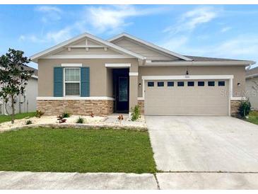 Charming single-story home with well-manicured lawn and neutral exterior at 5093 Meadow Song Dr, Okahumpka, FL 34762