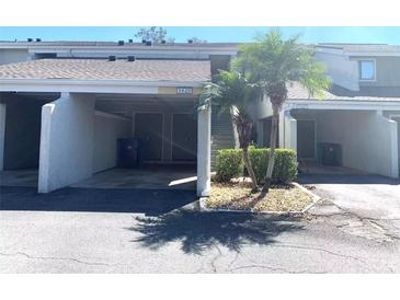 Exterior view of condo building, showing parking and landscaping at 5429 Vineland Rd # S, Orlando, FL 32811