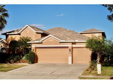 Two-story house with a three-car garage and landscaping at 6879 Remington View Ct, Orlando, FL 32829