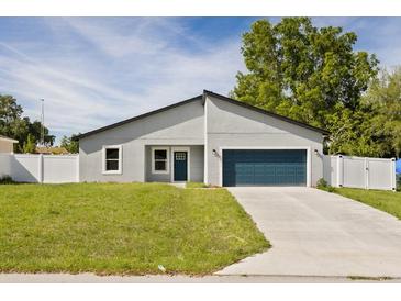 Charming single-story home features a well-manicured lawn, a two-car garage, and a classic white fence at 15033 Sw 35Th Cir, Ocala, FL 34473