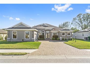 Single-story home with stone accents and a large driveway at 310 Lake Mariana Pl, Auburndale, FL 33823