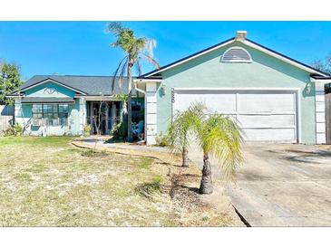 Charming single-story home with a two-car garage, palm trees and a well-maintained lawn at 3250 Dellbrook Dr, Deltona, FL 32738