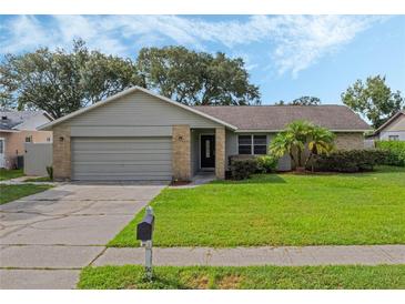 One-story house with a gray exterior, attached garage, and well-maintained lawn at 5405 Justine Way, Winter Park, FL 32792
