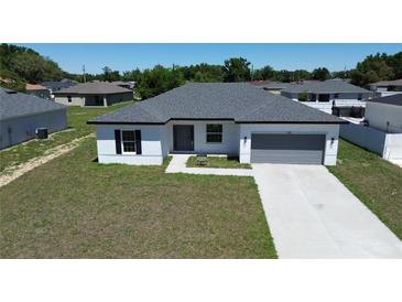 A charming single-story home boasts a well-manicured lawn and a welcoming, modern facade at 105 Marion Oaks Manor, Ocala, FL 34473