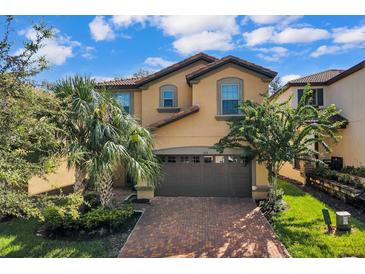 Two-story house with a brown garage door and brick driveway at 1913 Nice Ct, Kissimmee, FL 34747