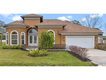 One-story house with brown roof, white garage door, and landscaping at 1943 Sipes Ave, Sanford, FL 32771