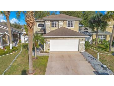 Two-story house with a white garage door and stone accents at 3251 Brewster Dr, Kissimmee, FL 34743