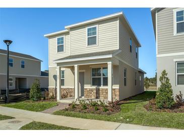 Two-story house with light beige siding and stone accents at 562 Orient Ave, Debary, FL 32713