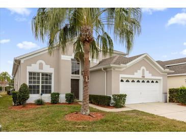 Beautiful two-story home with a two-car garage and palm trees at 8106 Fan Palm Way, Kissimmee, FL 34747