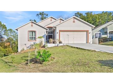 Charming single Gathering home with a 2-car garage, mature trees, and a lush lawn at 935 Don Wilson Ave, Apopka, FL 32712