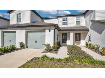 Front view of charming two-story townhome with light gray siding and landscaping at 1643 Wynford Cir, Tavares, FL 32778