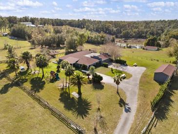 Expansive ranch-style home with sprawling grounds, pastures, and lush landscaping at 36129 E Eldorado Lake Dr, Eustis, FL 32736