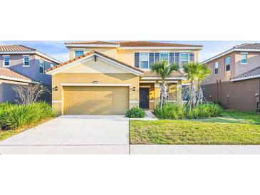 Two-story house with a two-car garage and landscaped lawn at 7619 Oakmoss Sw Loop, Davenport, FL 33837