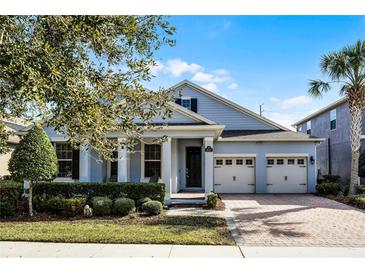 Beautiful two-story home with a light blue exterior, two-car garage, and well-manicured landscaping at 8547 Bayview Crossing Dr, Winter Garden, FL 34787