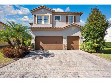 Two-story house with brown double garage and landscaped front yard at 10389 Henbury St, Orlando, FL 32832