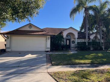 Single-story home with a two-car garage and well-maintained lawn at 10810 Dearden Cir, Orlando, FL 32817